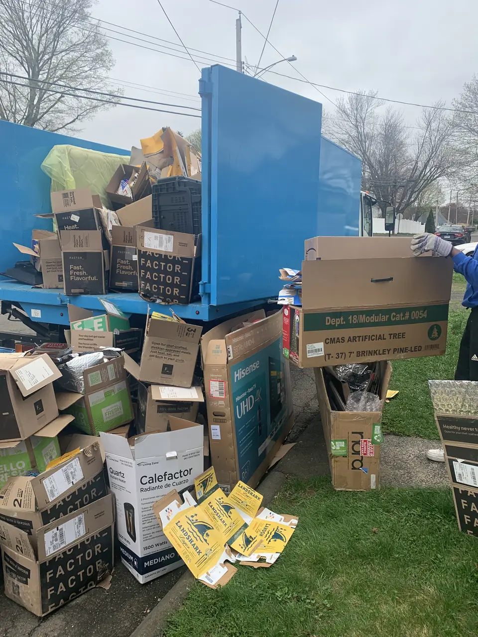 Junk Panthers crew member loading cardboard boxes into a Junk Panthers truck